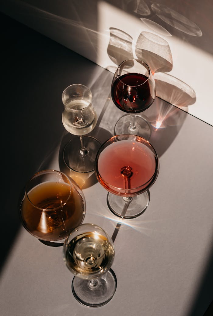 A sophisticated still life of wine glasses casting shadows under sunlight, ideal for luxurious event themes.